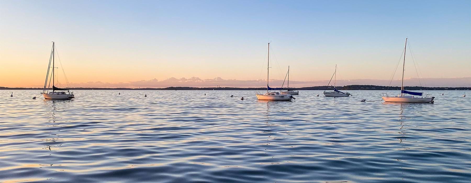 Sailboats anchored on calm water